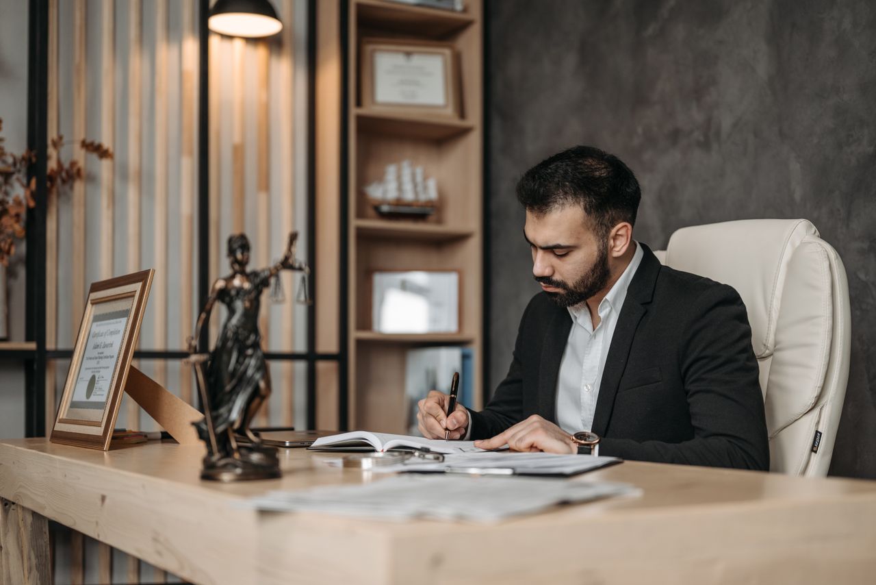 Mastering the First Impression: Your intriguing post title goes here A focused lawyer in an office setting writing and reviewing legal documents, symbolizing expertise and professionalism.