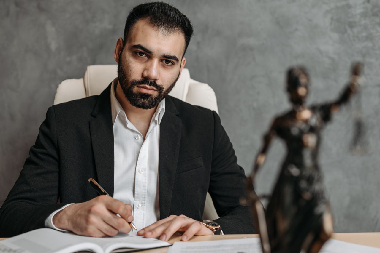 The Art of Drawing Readers In: Your attractive post title goes here A serious lawyer in a black suit working diligently at his office desk.